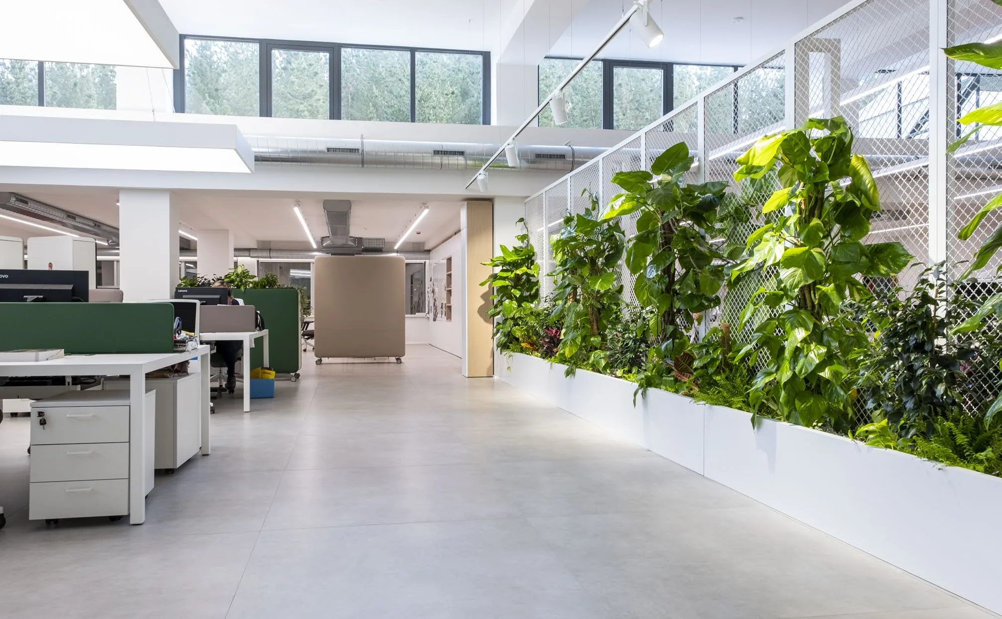 Oficina con luz natural y vegetación equipada con mobiliario Actiu